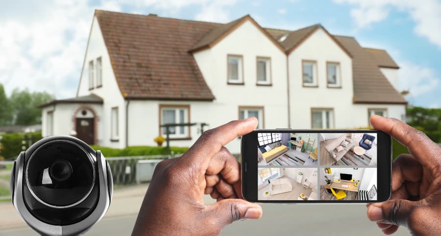 Man holding mobile device and viewing streams from security cameras